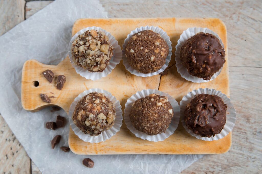 top view of chocolate balls with different toppings on a cutting board
