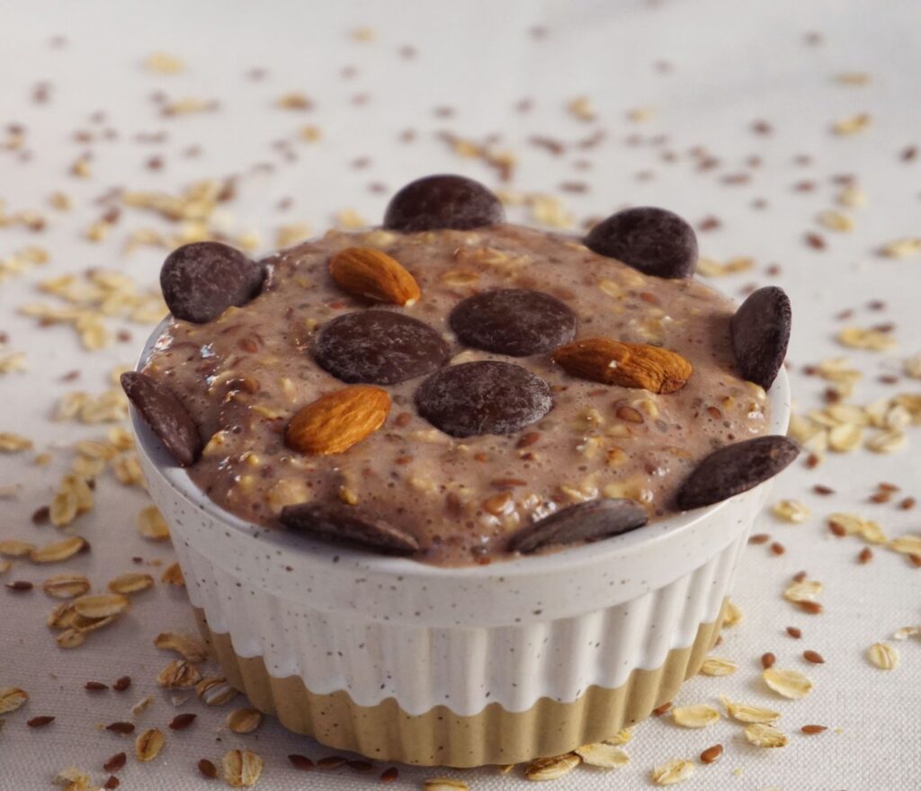 a cup of chocolate pudding with nuts and chocolate chips
