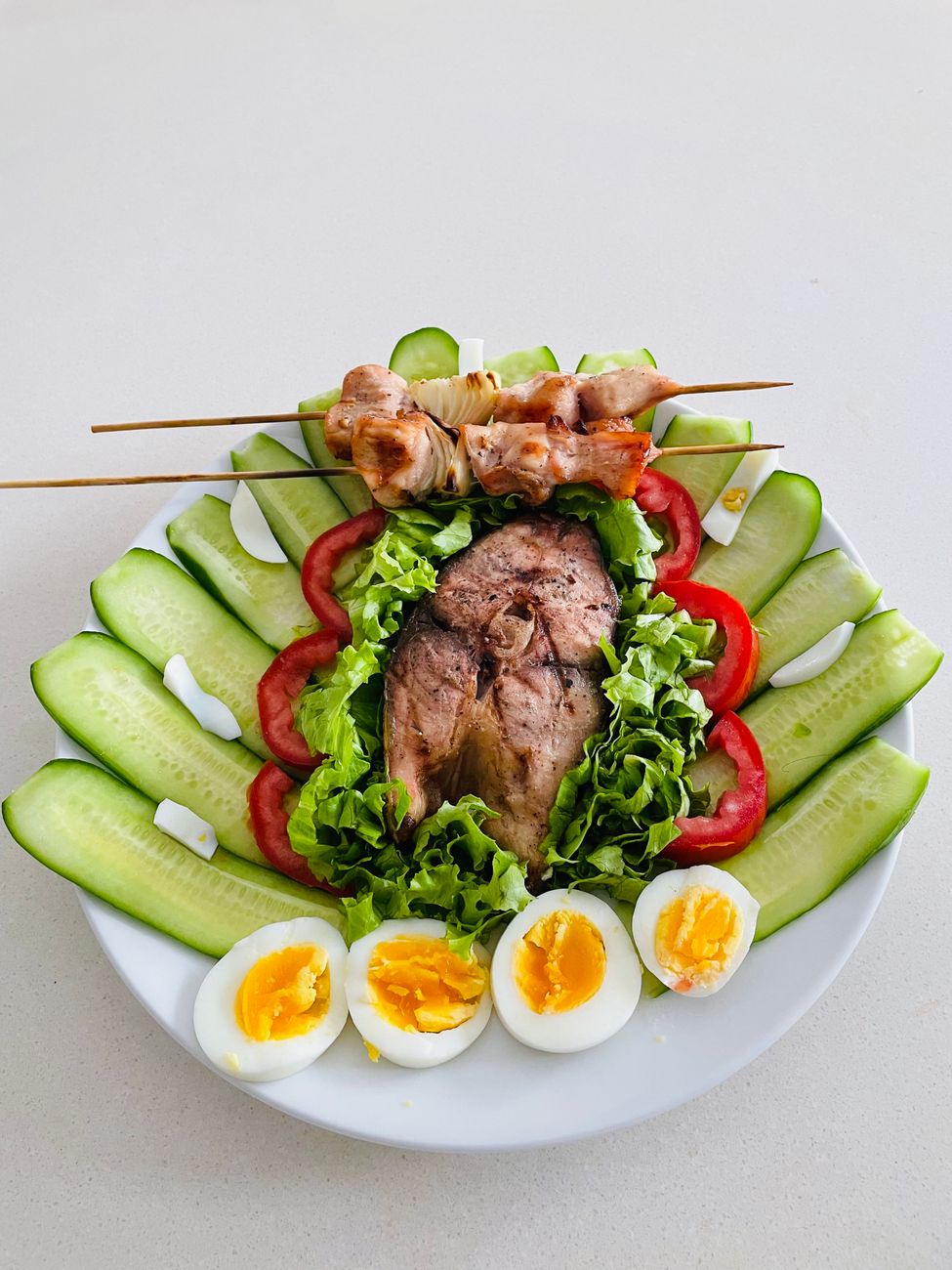 a plate with a salad eggs and meat