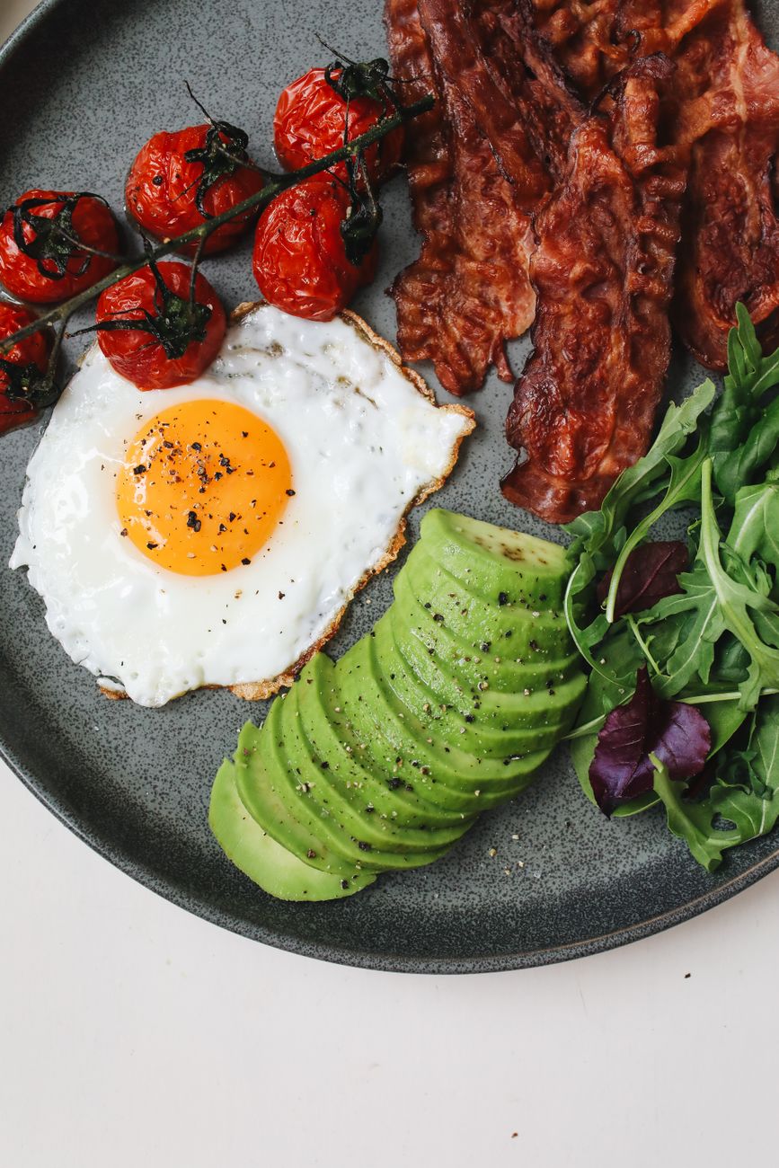 fried egg and sliced cucumber on a black plate